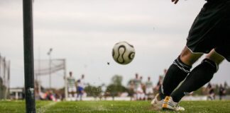 A soccer player kicks for goal.